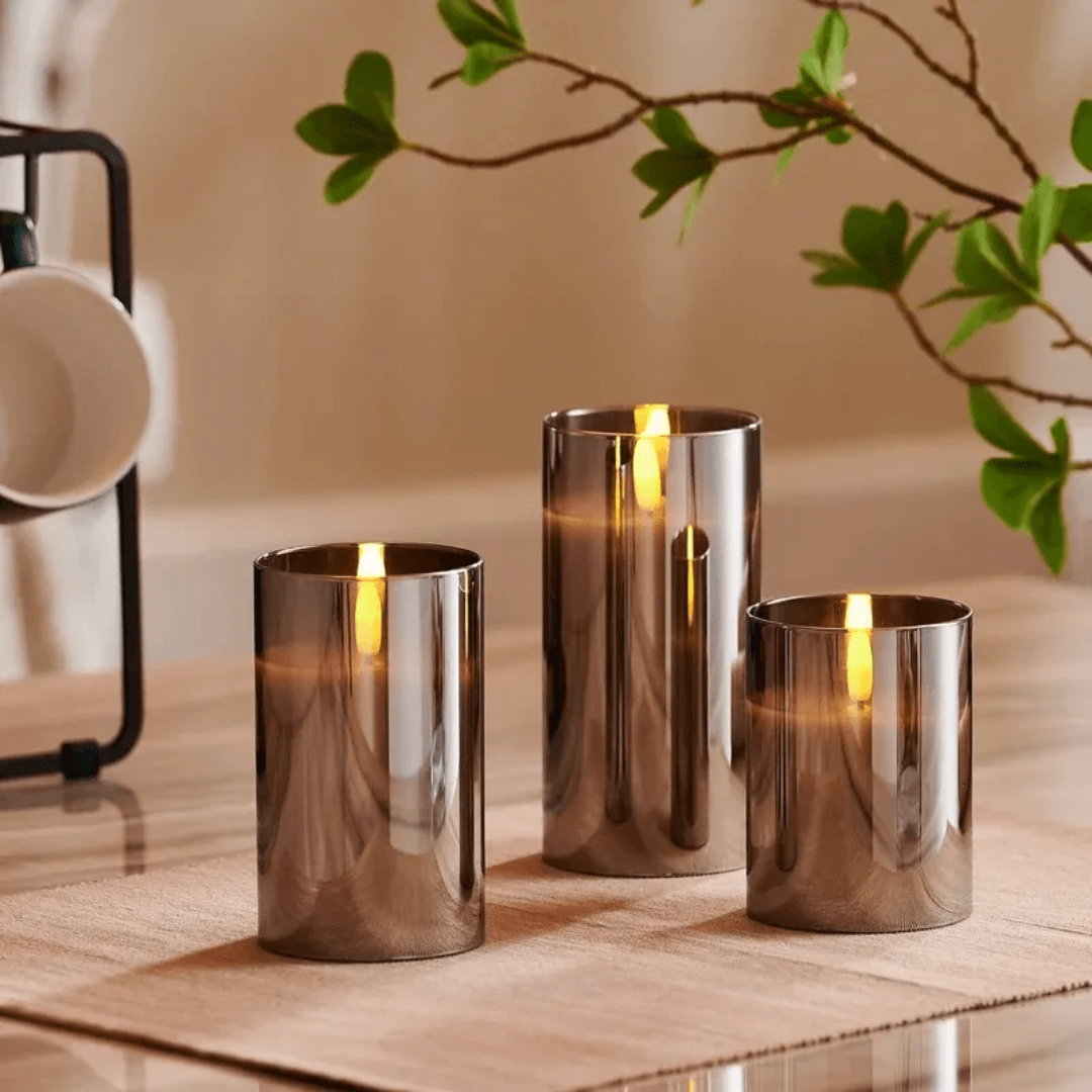 Drei silberne LED-Kerzen auf Holztisch, moderne Dekoration, warmes Licht, Wohnzimmer.
