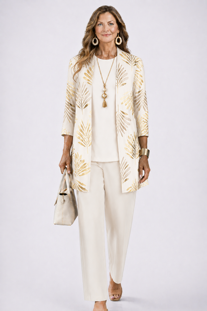 Frau im cremeweißen Set, Cardigan mit goldenem Palmblattmuster über schlichtem Oberteil und Hose, frontal. 3