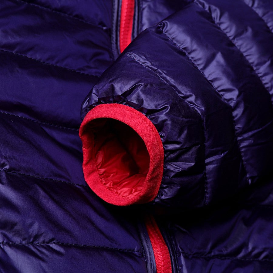 Dunkelblaue Daunenjacke mit rotem Reißverschluss und Bündchen, Wintermode, warm, stilvoll.