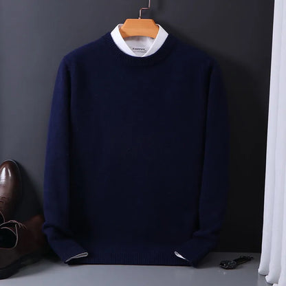 Dunkelblauer Herrenpullover aus Wolle, elegant, auf Holzkleiderbügel vor grauem Hintergrund.