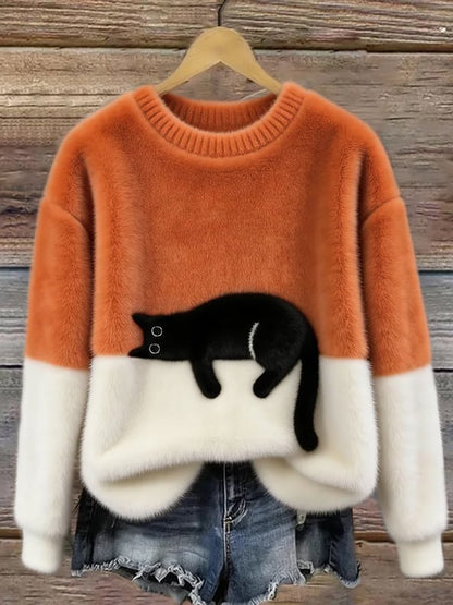 Flauschiger Pullover in Orange und Weiß mit schwarzer Katze, am Holzbügel vor Jeansshorts 3