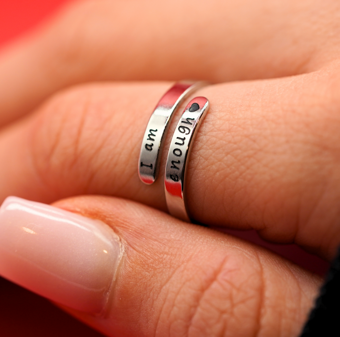Silberne Motivationsringe mit Gravur "I am enough", getragen an einer Hand.