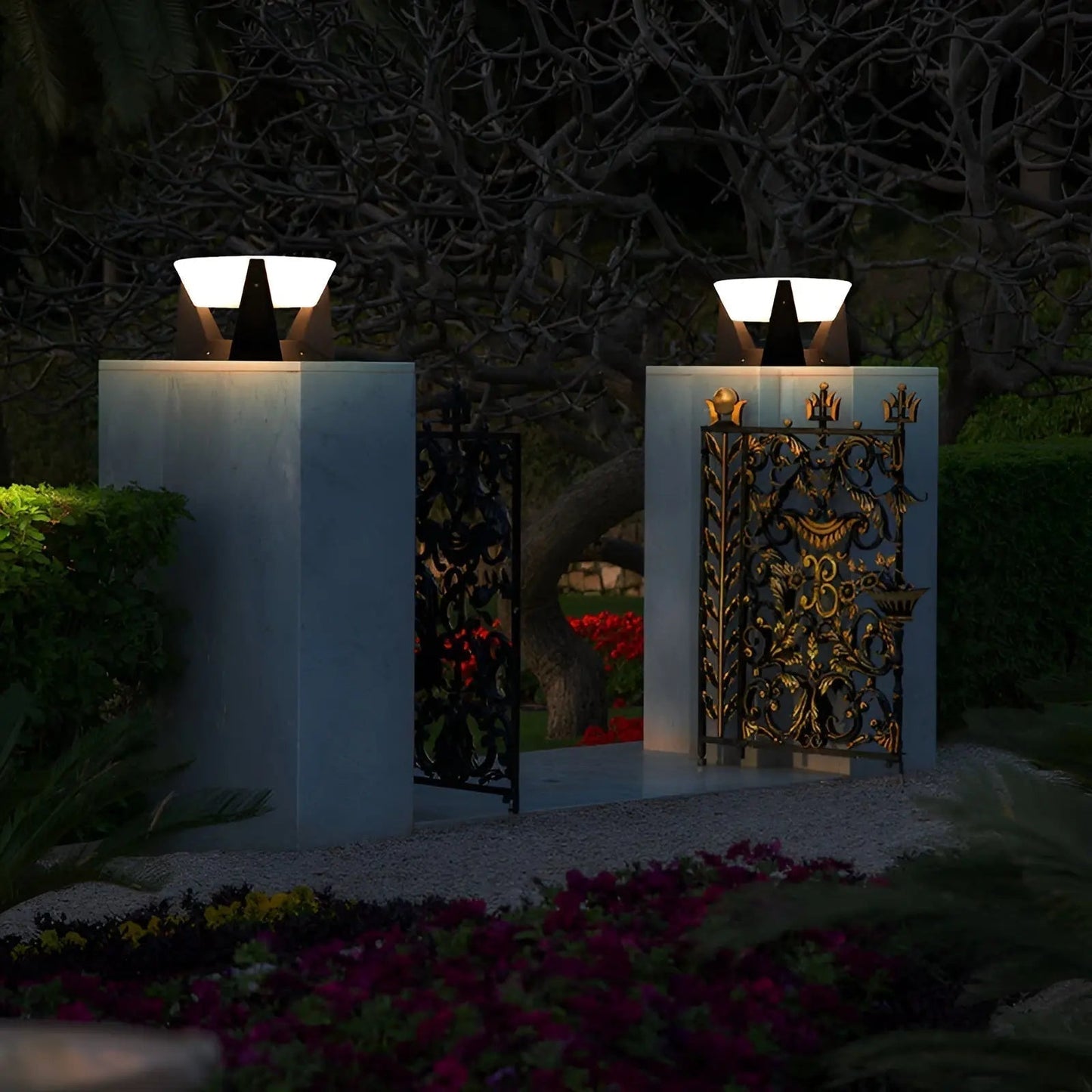 Tor mit dekorativen Metallverzierungen und modernen Außenleuchten bei Nacht im Garten.