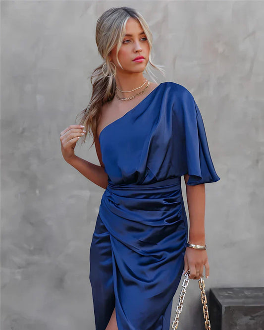 Frau in blauem, einärmeligem Satinkleid mit Kette, elegantes Abendoutfit.