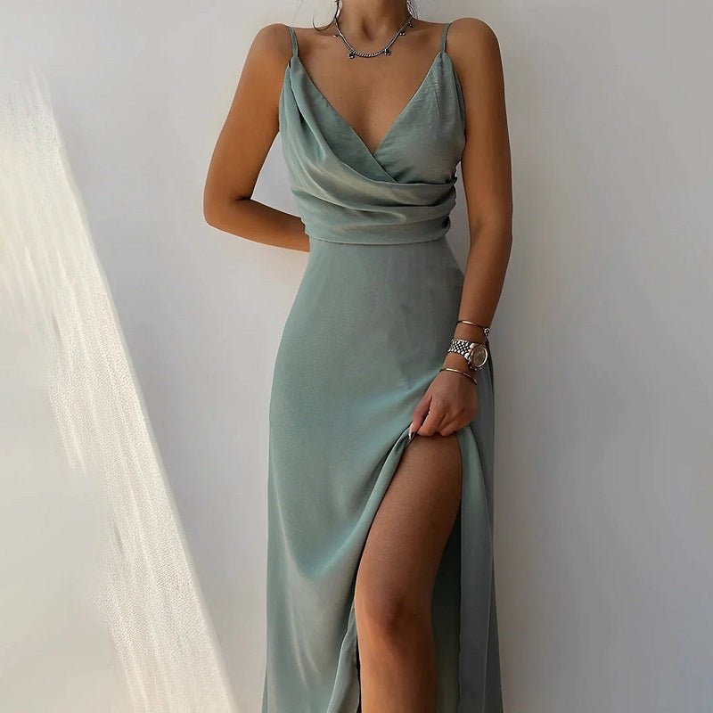 Frau in eleganter, langer, grüner Abendkleid mit Spaghettiträgern und Beinschlitz.