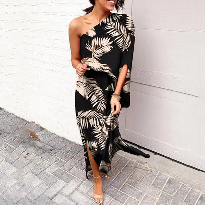Frau in schwarzem, schulterfreiem Maxikleid mit Palmenmuster, elegant, sommerlich, modisch.