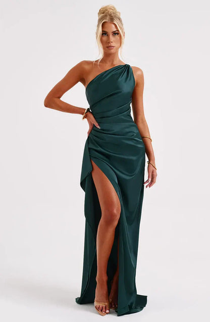 Frau in elegantem, smaragdgrünem, schulterfreiem Abendkleid mit hohem Schlitz.