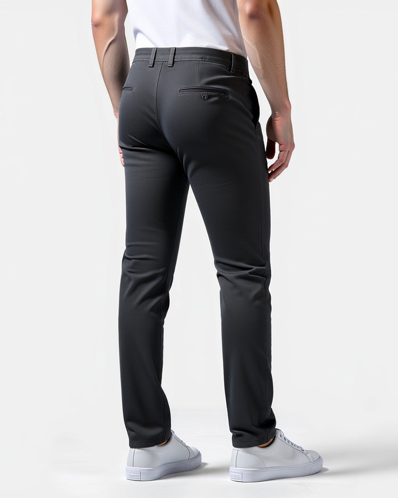 Rückansicht der anthrazitfarbenen Chino mit Paspeltaschen am Gesäß, Gürtelschlaufen und weißen Sneakern. 8