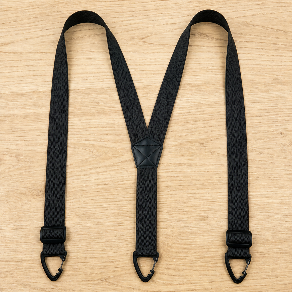 Schwarze Y-Hosenträger mit Verstellschnallen nahe den Clips und kleinem Kunstleder-Mittelstück, auf hellem Holz ausgelegt. 13
