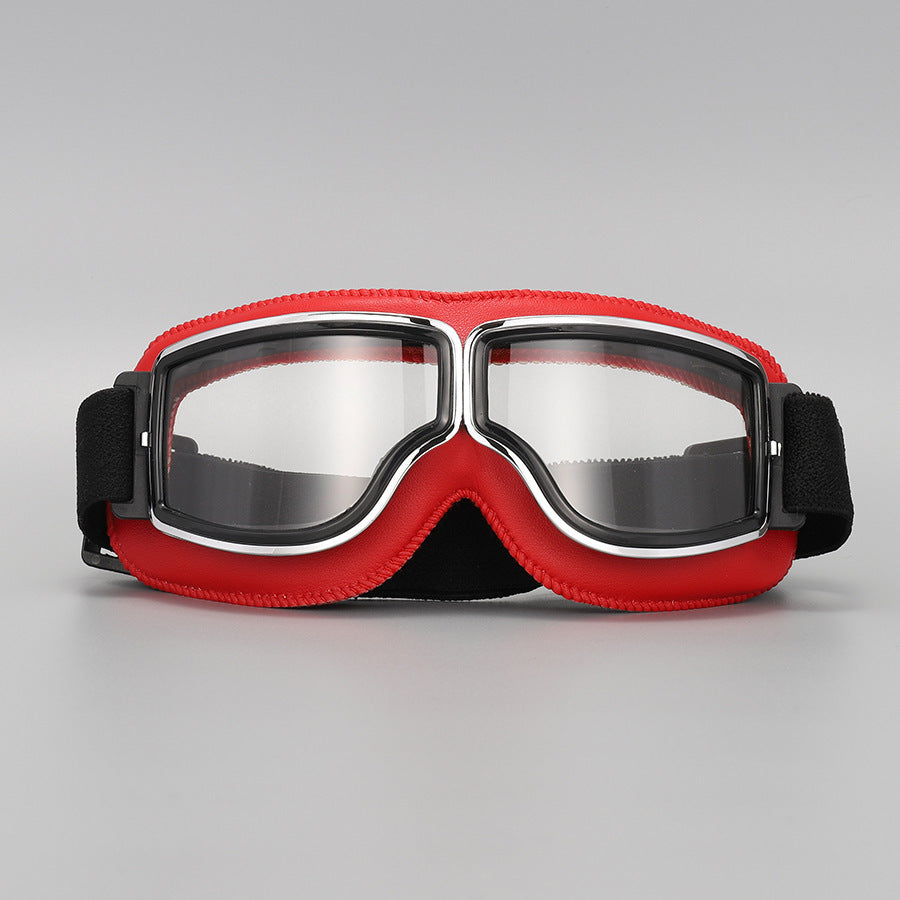 Fliegerbrille mit roter Lederpolsterung, Chromrahmen und klaren Gläsern, Vorderansicht mit schwarzem elastischem Band. 10