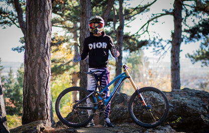 Mountainbiker mit blauem Fahrrad und Helm im Wald, Outdoor-Abenteuer, Fahrradfahren.