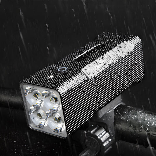 Wasserdichte LED-Fahrradleuchte, schwarz, mit vier Linsen, montiert auf Lenker, bei Regen.