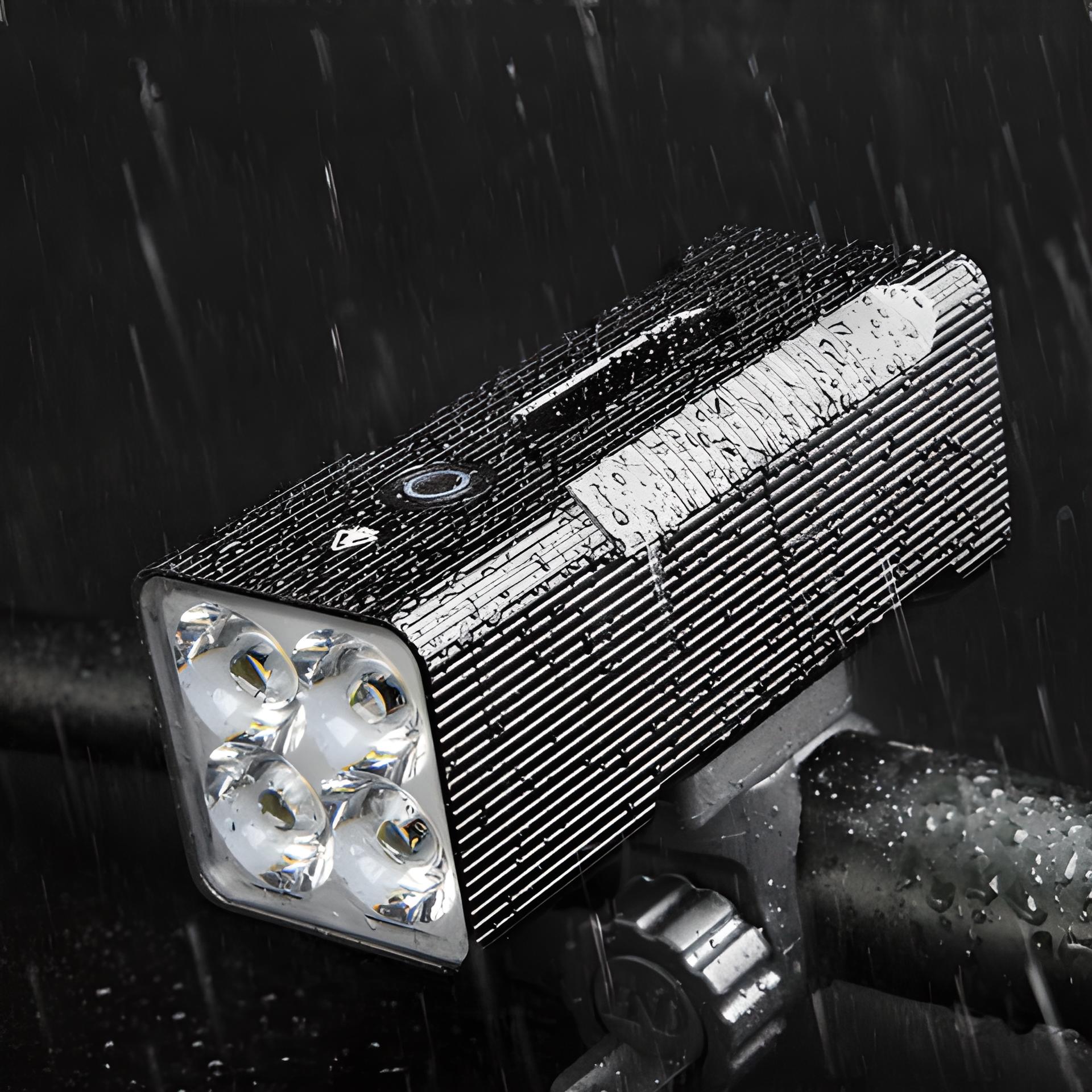 Wasserdichte LED-Fahrradleuchte, schwarz, mit vier Linsen, montiert auf Lenker im Regen.