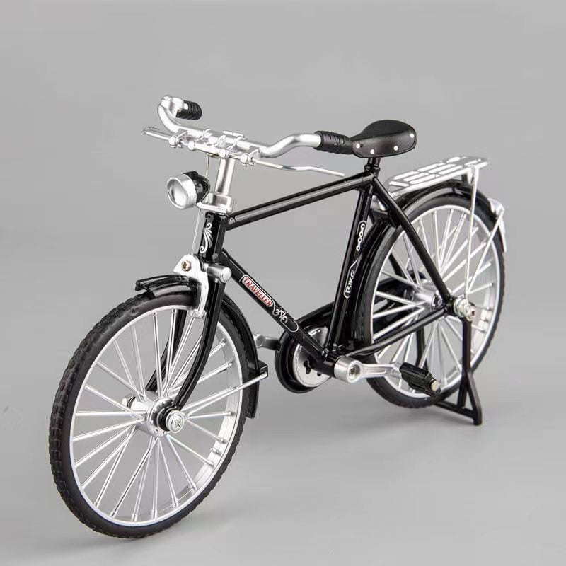 Schwarzes Miniatur-Fahrradmodell aus Metall, detailgetreu, auf grauem Hintergrund.