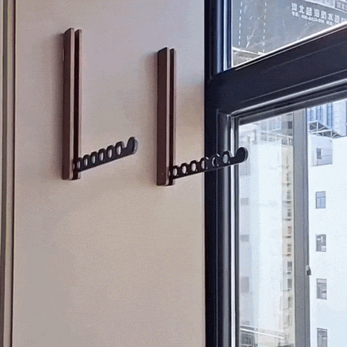 Zwei dunkle Wandhalter mit ausgeklapptem schwarzem Locharm, montiert an einer Wand neben einem Fenster. 2