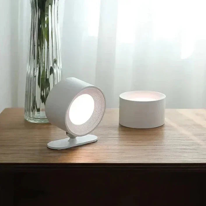 Weißer LED-Tischstrahler auf Holzoberfläche, modernes Design, energiesparend.