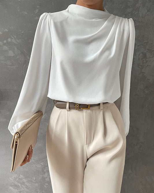 Weiße Damenbluse aus Satin, elegantes Design, kombiniert mit beigen Hosen, stilvoller Look.