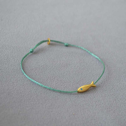 Grünes Armband mit gelbem Fischanhänger, handgefertigt, minimalistisches Schmuckdesign.