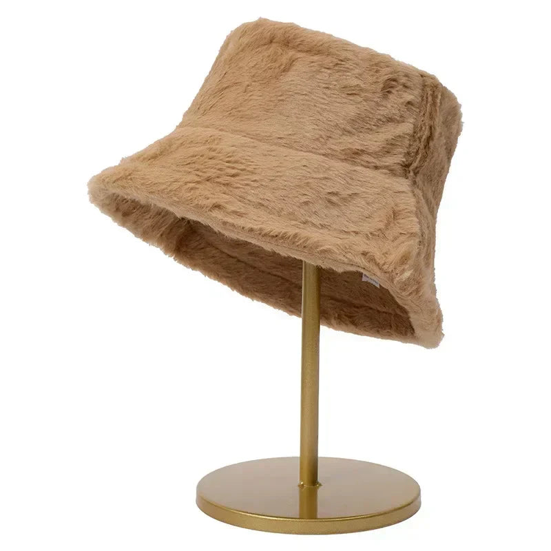 Beigefarbener Kunstpelz-Bucket-Hut auf goldenem Ständer, modisches Accessoire.