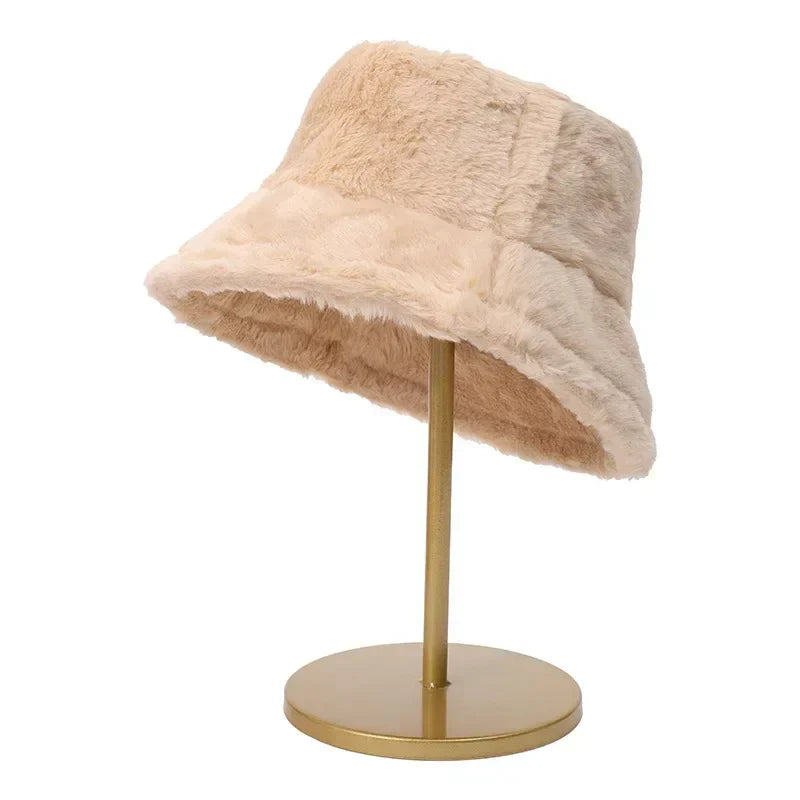 Beiger Kunstpelz-Bucket-Hut auf goldenem Ständer, modisches Accessoire für Herbst und Winter.