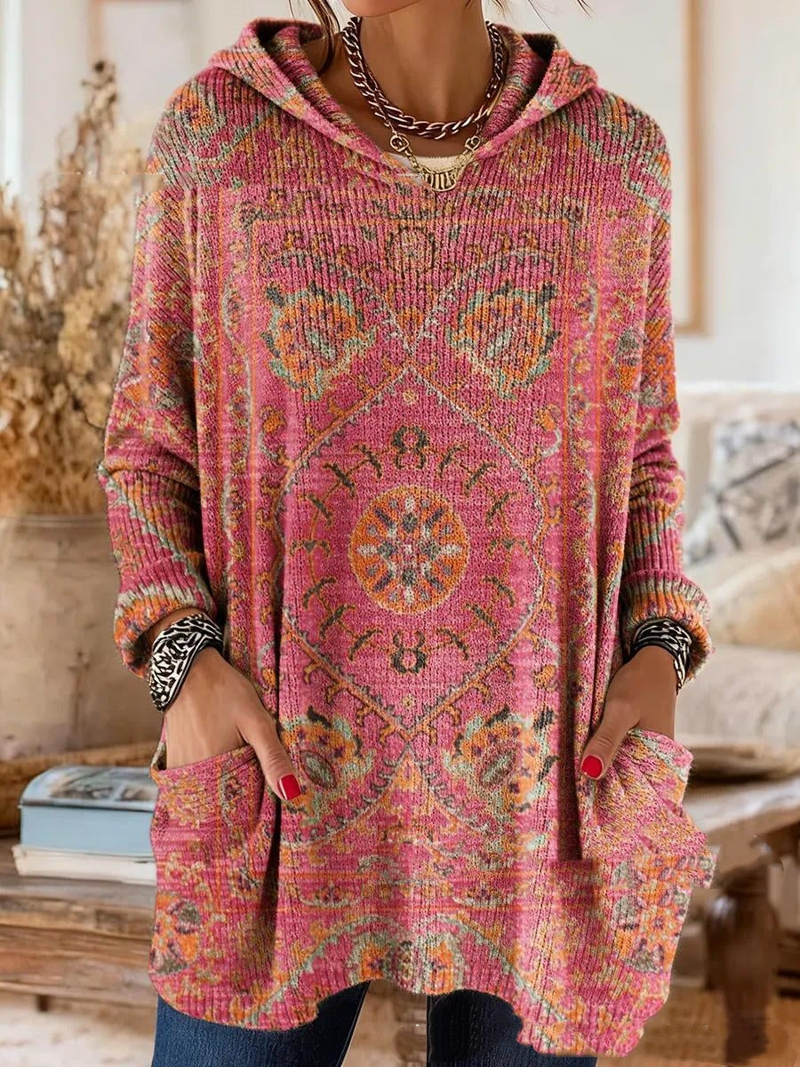 Von einem Model getragene Tunika in Pink mit orangefarbenem Ornamentmuster, locker geschnitten mit Kapuze und Taschen. 6