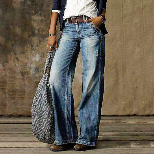 Frau in blauen, weiten Jeans mit niedriger Taille, Retro-Stil, Straße, Mode, graue Tasche.