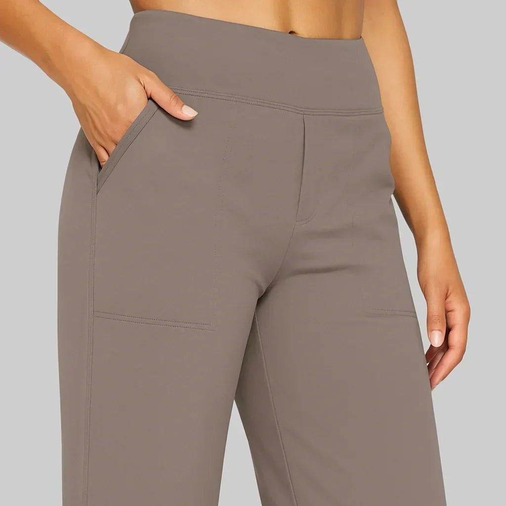 Nahaufnahme von Bund und Taschen der taupefarbenen Hose, eine Hand steckt in der Seitentasche. 3
