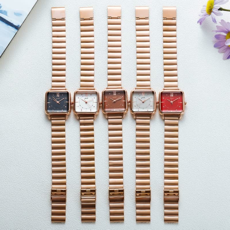 Fünf roségoldene Armbanduhren mit quadratischem Zifferblatt in verschiedenen Farben auf weißem Hintergrund.