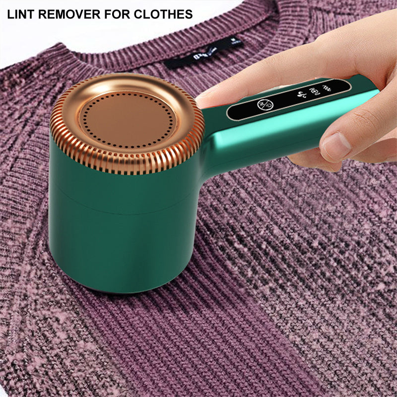 Grüner elektrischer Fusselentferner für Kleidung auf lila Pullover, tragbar, effizient.