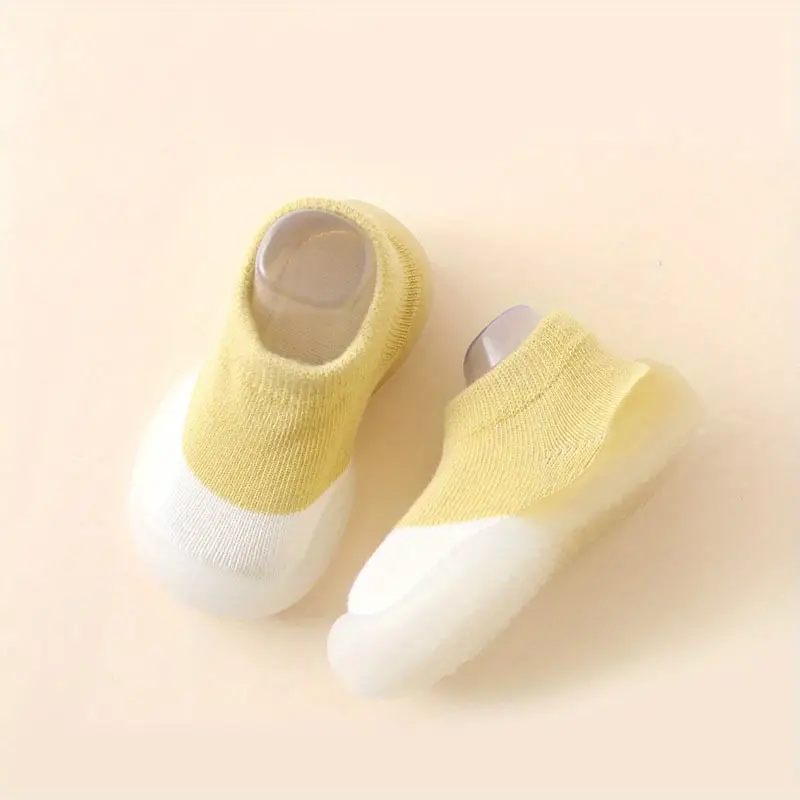 Gelbe Babyschuhe mit weißer Sohle, rutschfest, weiches Material, ideal für Kleinkinder.