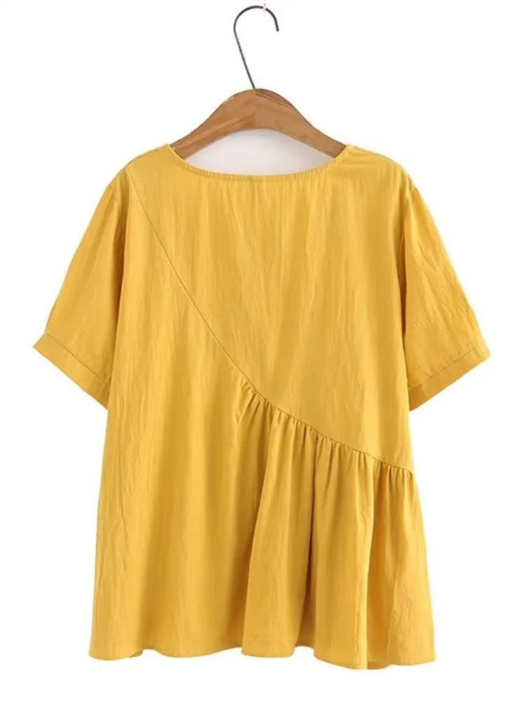 Gelbes Damenbluse aus Baumwolle, Kurzarm, lässiger Stil, Sommermode, auf Holzkleiderbügel.