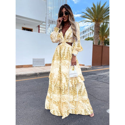Frau in gelbem Maxikleid mit Blumenmuster, Sonnenbrille und Handtasche, steht auf Straße.