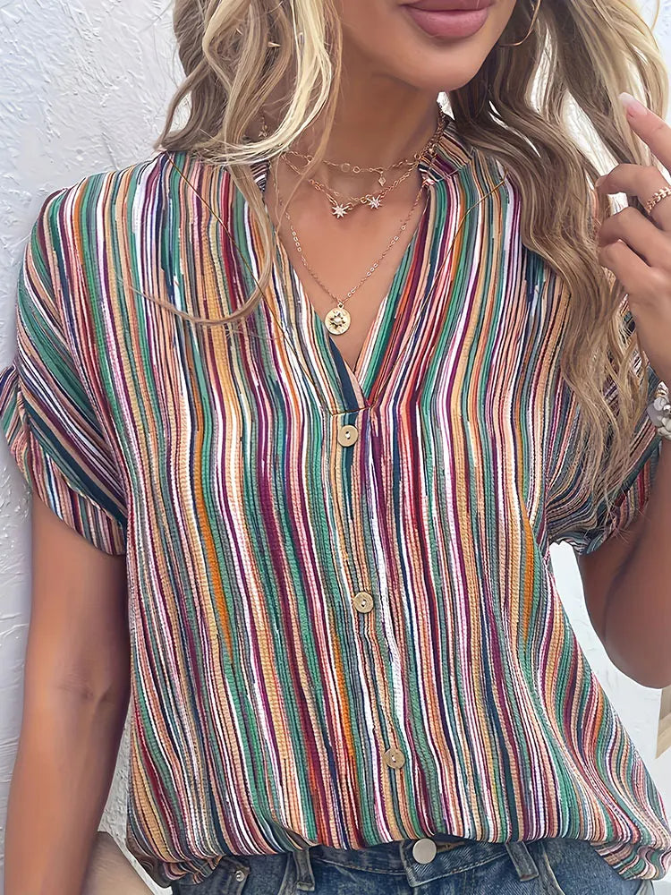 Frau trägt bunt gestreifte Bluse, V-Ausschnitt, kurze Ärmel, lässiger Sommerlook.