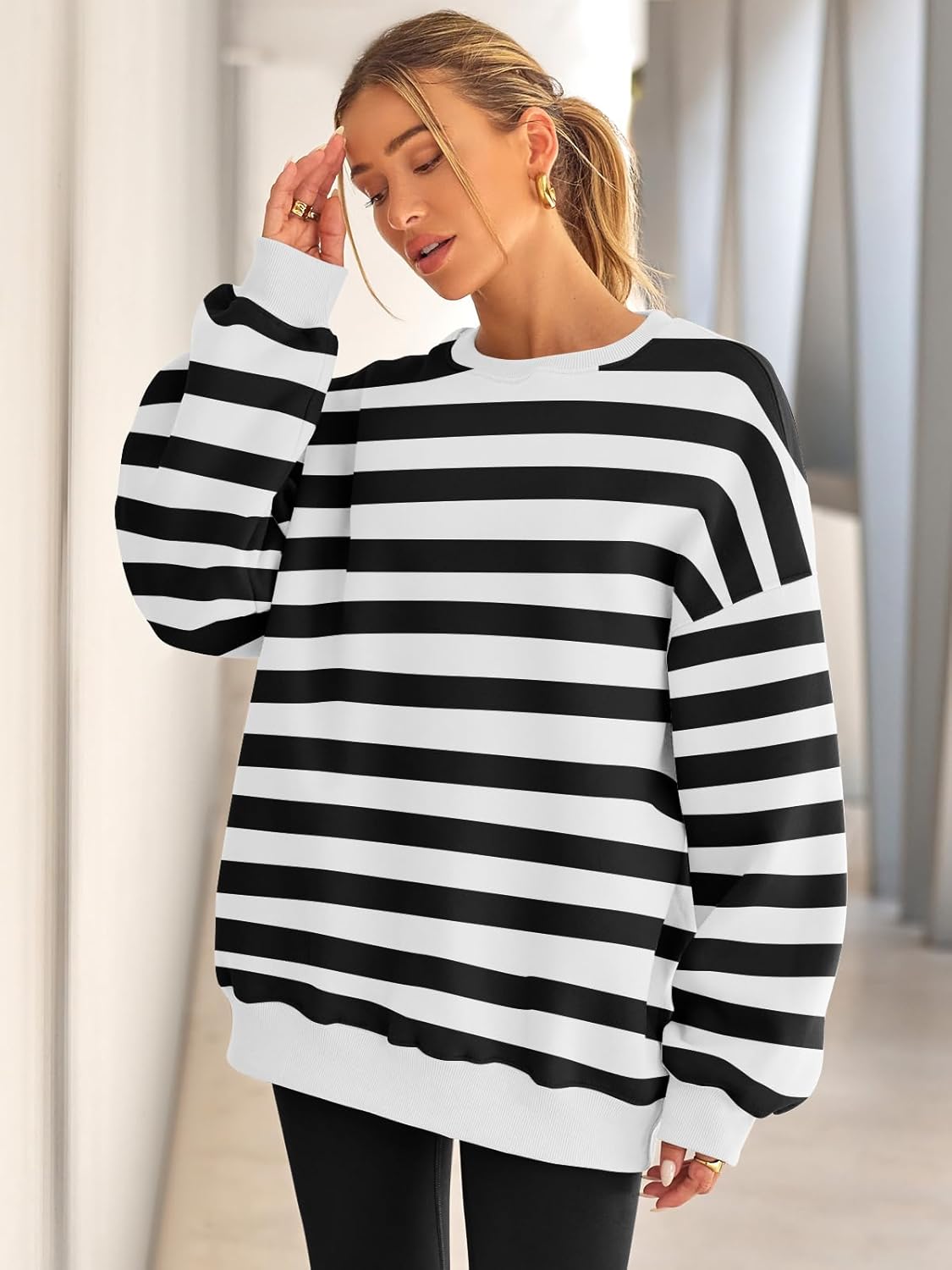 Frau in schwarz-weiß gestreiftem Pullover, lässige Mode, Herbstkleidung, Innenraum.