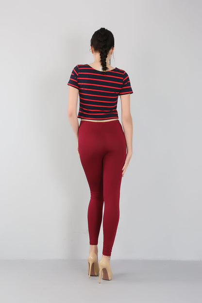 Frau in rot-blau gestreiftem T-Shirt und roten Leggings, Rückansicht, Mode, Freizeitkleidung.