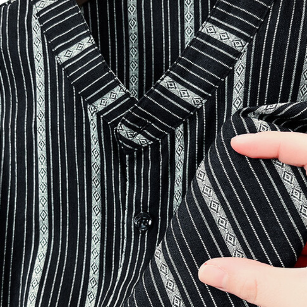 Schwarz-weiß gestreiftes Hemd aus Baumwolle, Nahaufnahme, Hand hält Stoff, modisches Design.
