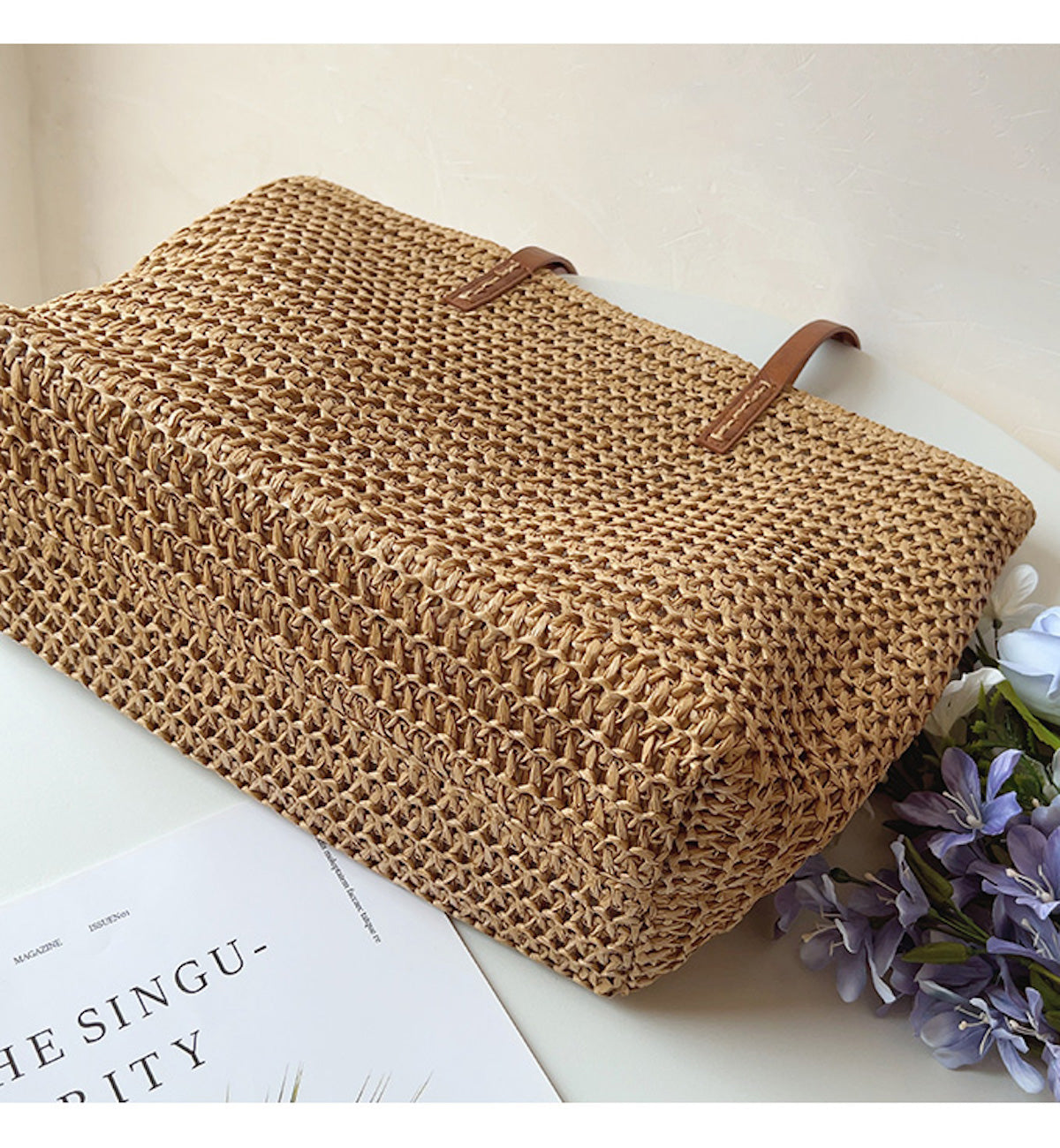 Geflochtene Strohtasche mit braunen Griffen, ideal für Sommer, Picknick oder Strand.