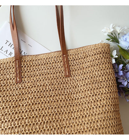 Geflochtene Strohtasche mit braunen Ledergriffen, Blumen und Zeitschrift, Sommermode Accessoire.