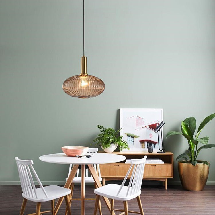 Hängelampe aus braunem Glas, skandinavisches Design, über Esstisch, moderne Inneneinrichtung.