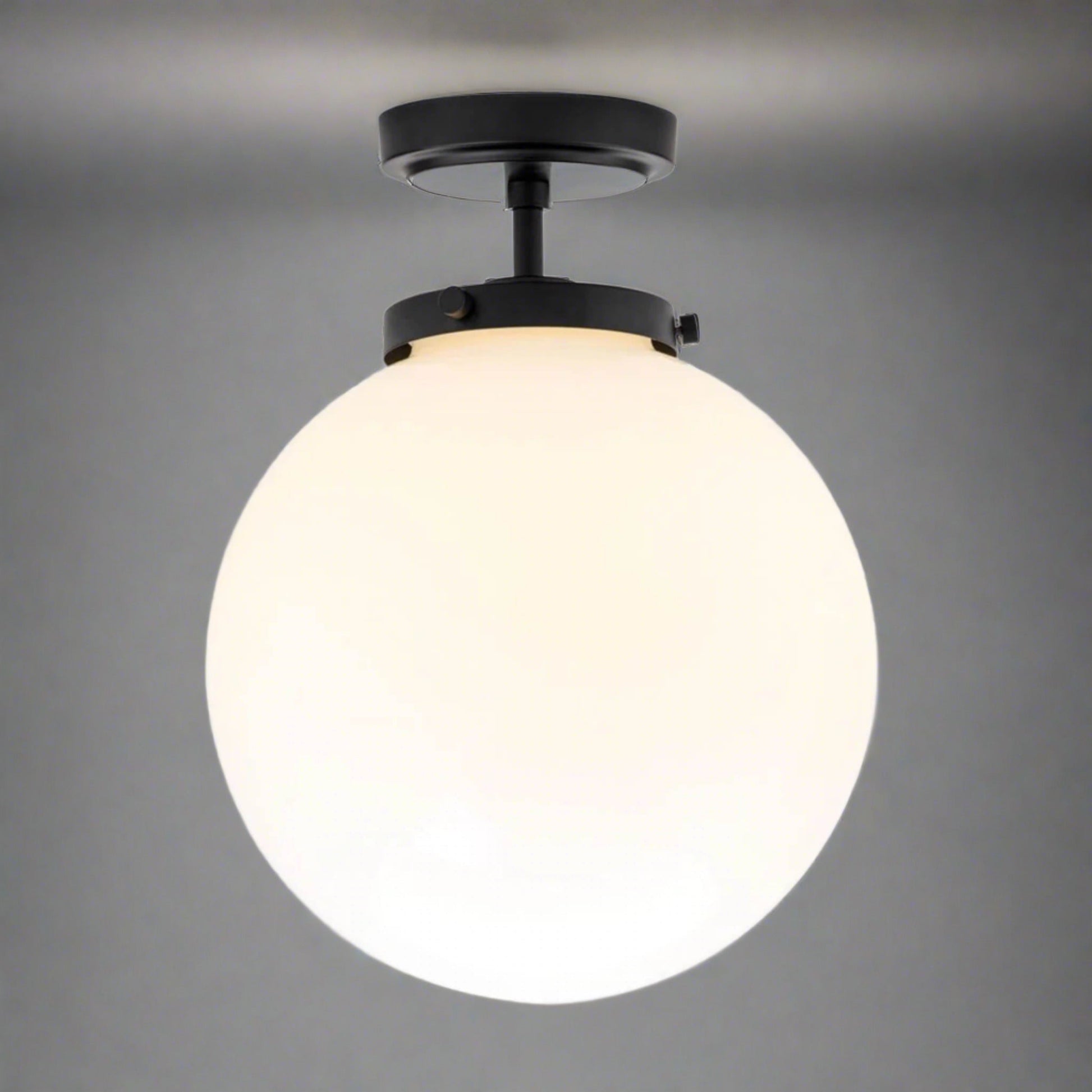 Schwarze Deckenleuchte mit weißem Glaskugel-Schirm, modernes Design, für Badezimmer geeignet.
