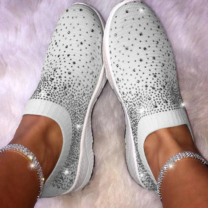 Weiße Damen-Sneaker mit Strasssteinen, glitzernd, modisch, bequem, auf weißem Hintergrund.