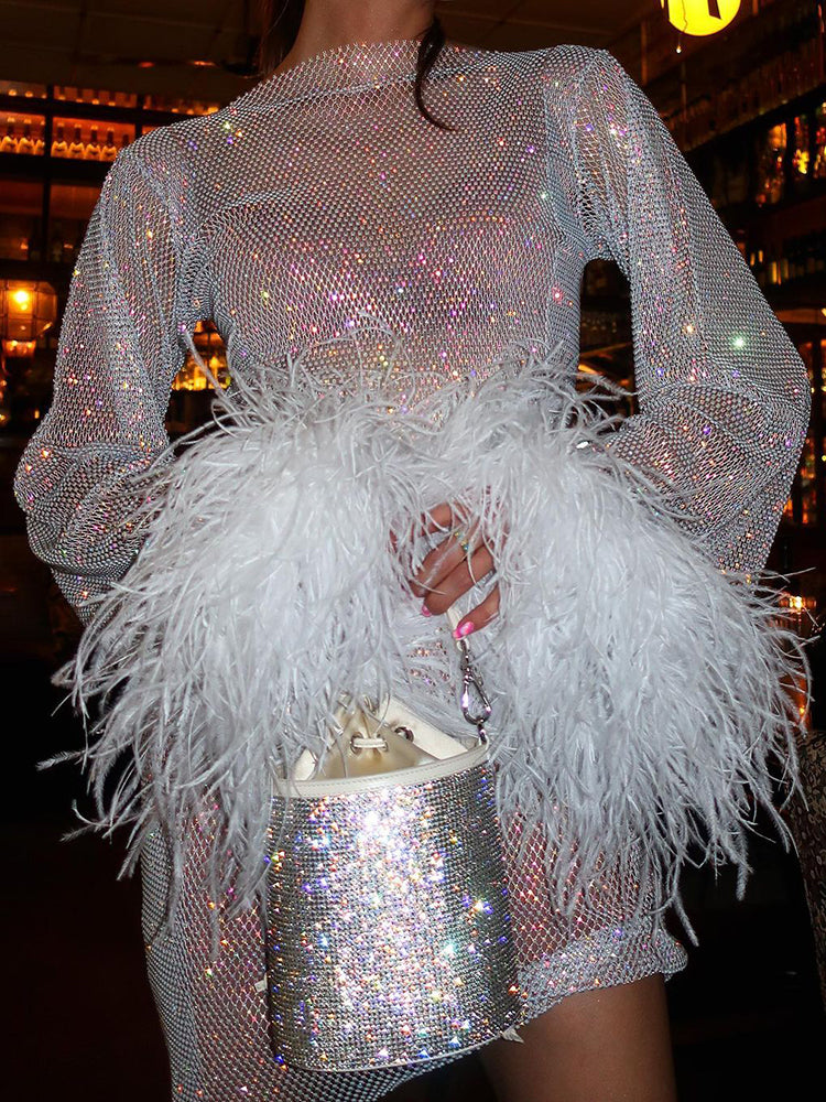 Funkelndes silbernes Paillettenkleid mit weißen Federn, glamouröses Abendoutfit, Damenmode.