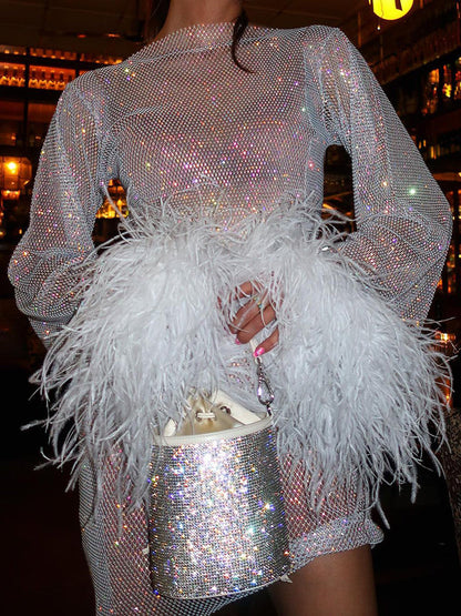 Funkelndes silbernes Paillettenkleid mit weißen Federn, glamouröses Abendoutfit, Damenmode.
