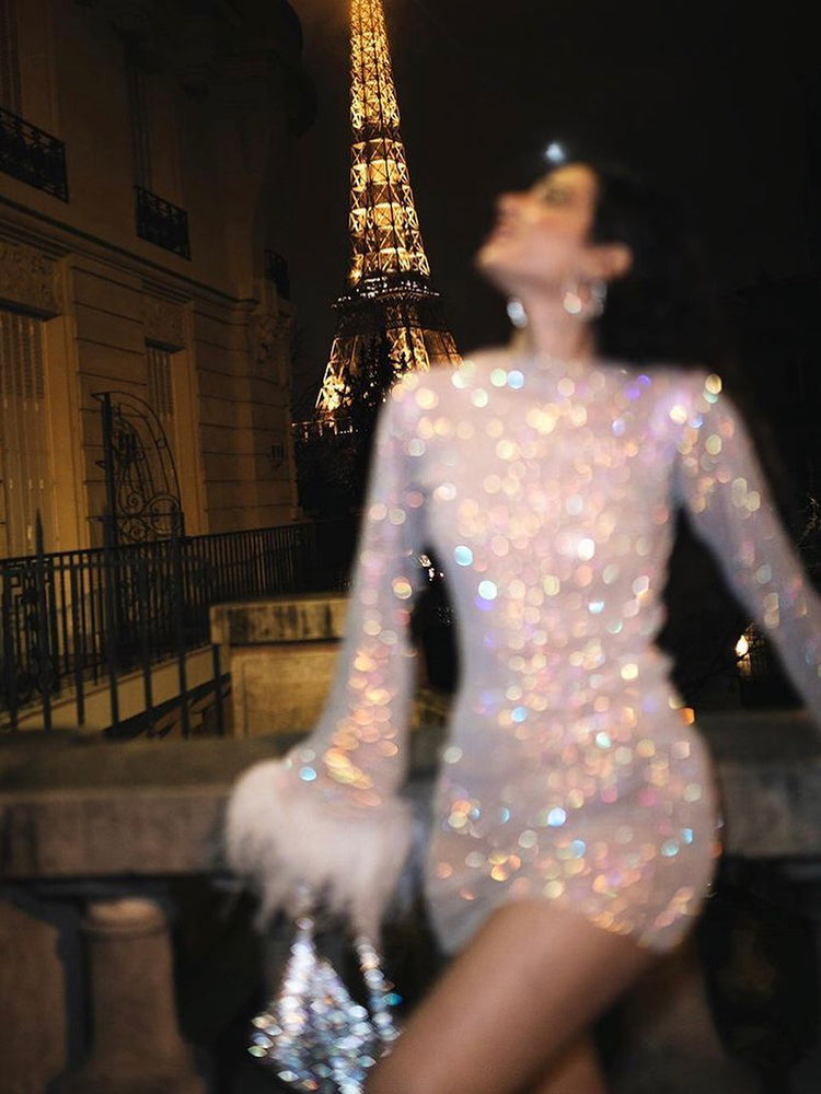 Frau in glitzerndem Kleid vor Eiffelturm bei Nacht, glamouröses Abendoutfit, Paris.