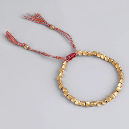 Goldenes Perlenarmband mit verstellbarem, buntem Kordelverschluss, handgefertigt.