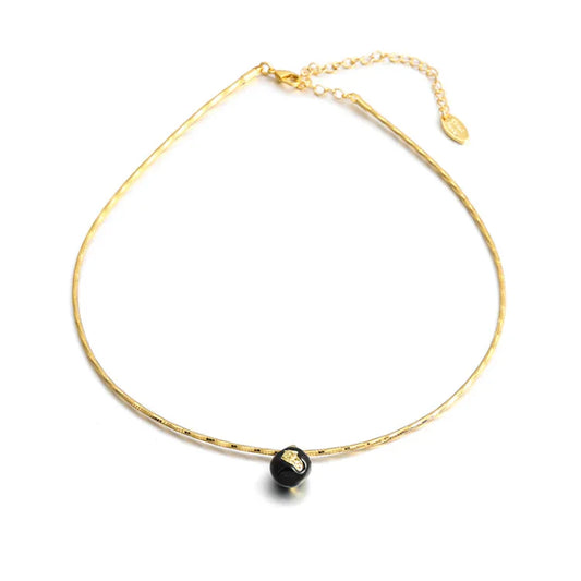 Goldene Halskette mit schwarzem Anhänger, elegantes Schmuckstück, verstellbare Länge.