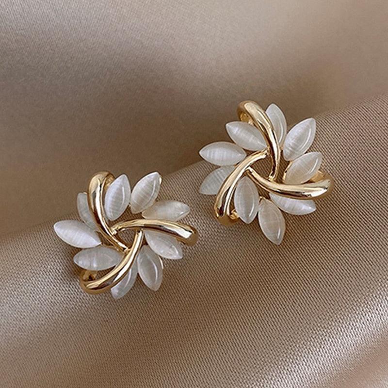 Goldene Ohrringe mit weißen Blättern, elegantes Design, Modeschmuck, Damenaccessoire.