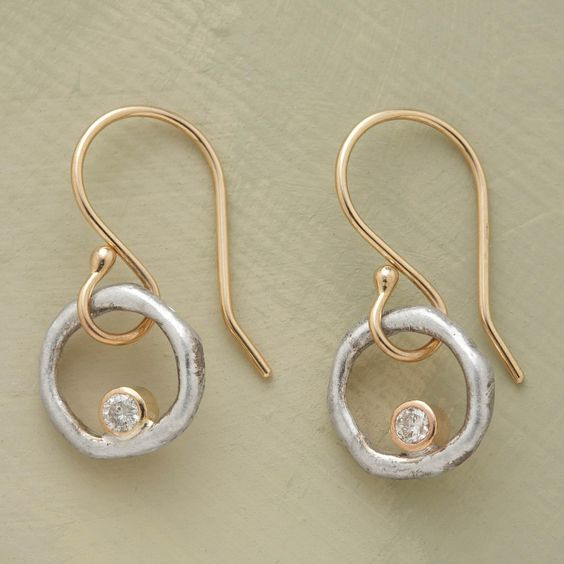 Goldene Ohrringe mit silbernen Kreisen und Diamant, eleganter Schmuck für Damen.