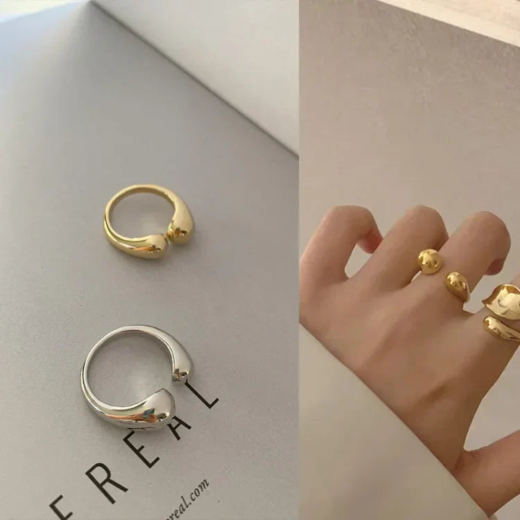 Zwei minimalistische Ringe, gold und silber, auf Papier, moderner Schmuck, stilvoll, elegant.
