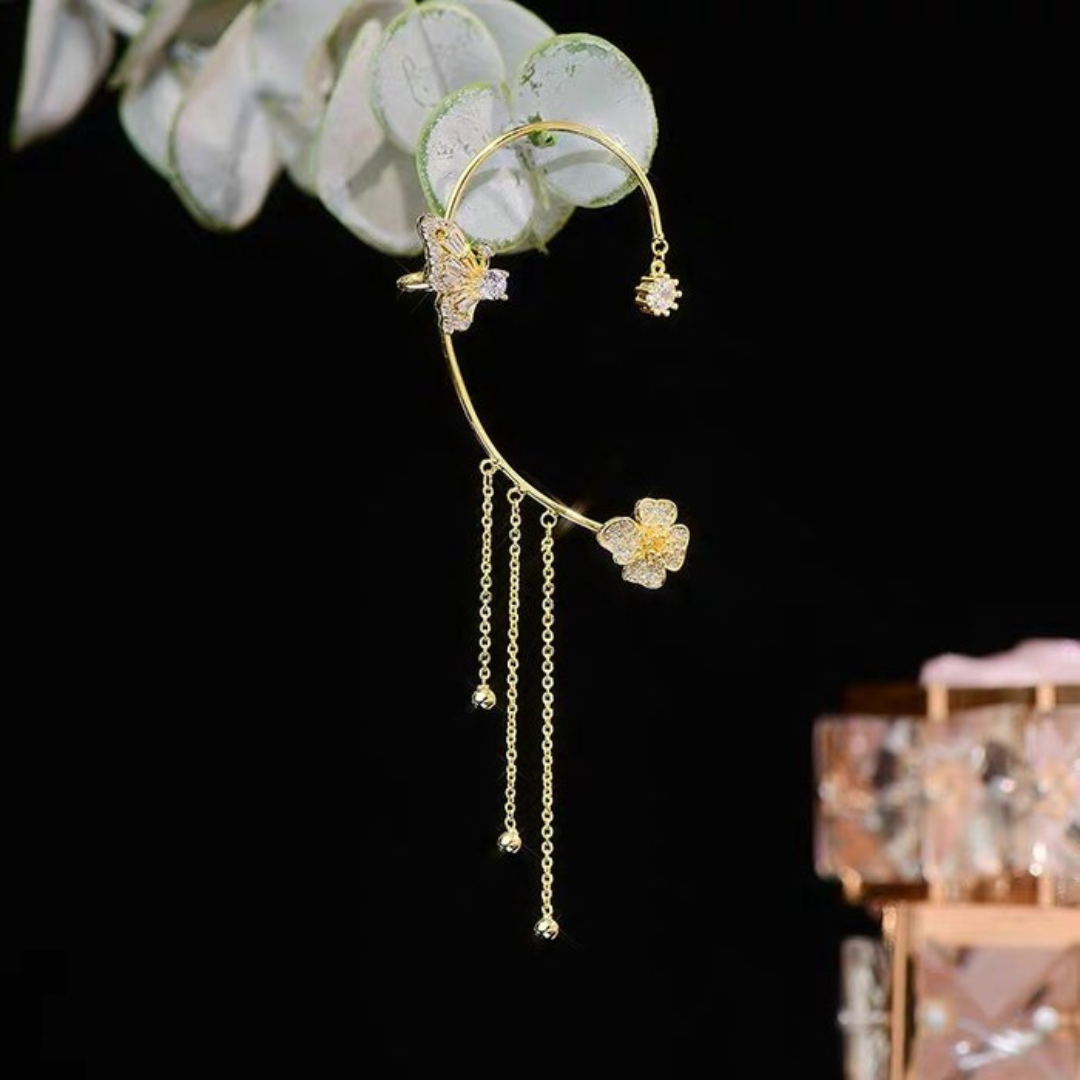 Goldener Ohrring mit Blumenmotiv, hängenden Ketten und Kristallen, eleganter Schmuck für Damen.